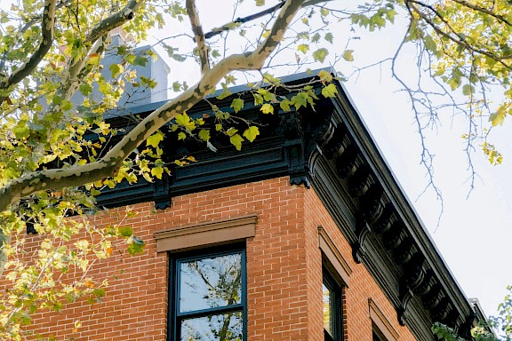 Architekturdetail eines historischen Hauses mit schwarzen Verzierungen und Fenstern.