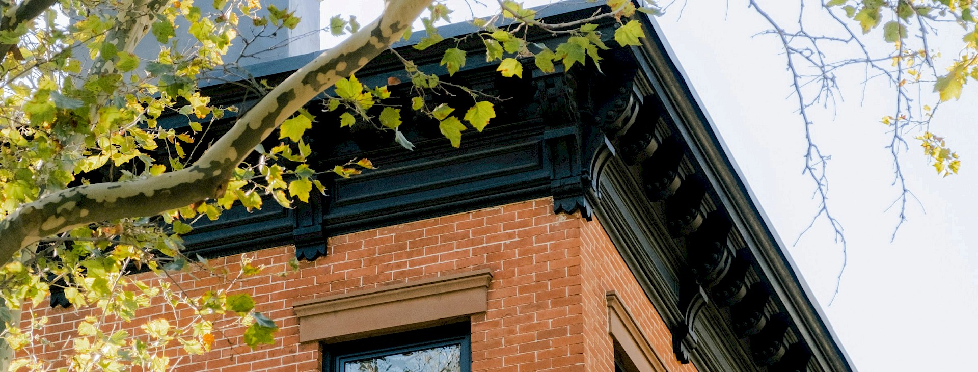 Architekturdetail eines historischen Hauses mit schwarzen Verzierungen und Fenstern.